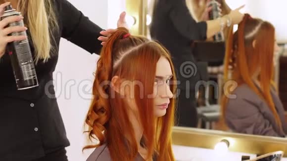 发型师的女人为模特的女孩做卷发师傅准备模型头发视频的预览图
