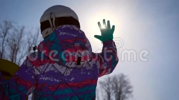 大气框架梦想和欢乐的概念一个滑雪的女孩用手抓住了一个明亮的太阳A视频的预览图