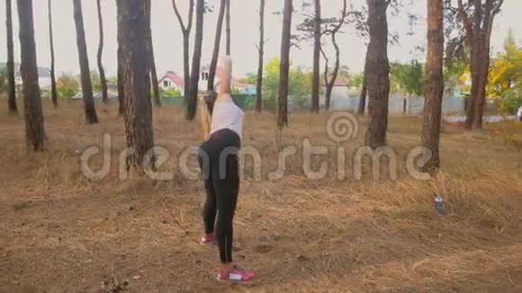在森林里做热身运动的年轻女子慢镜头视频的预览图