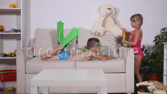 男孩模仿在沙发上游泳女孩在他身上吹泡泡视频的预览图