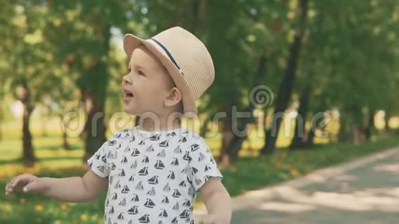 戴帽子的小孩子捕捉泡泡小男孩夏天在外面玩视频的预览图