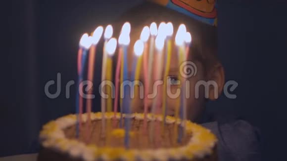 小男孩看着生日蛋糕上的蜡烛微笑着视频的预览图