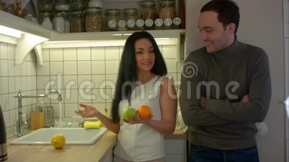 晚上年轻女子在厨房里给男朋友送新鲜水果视频的预览图