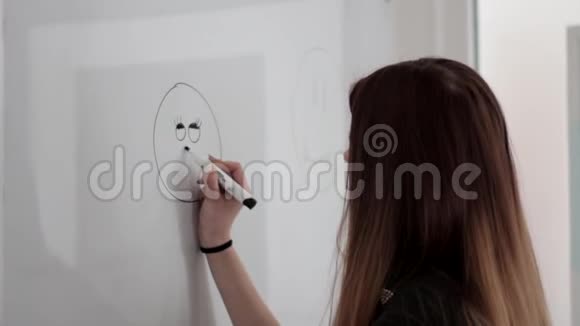 年轻女孩留着长发在白板上画着快乐的笑脸视频的预览图