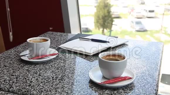 女人手拿着咖啡在咖啡馆写日记视频的预览图