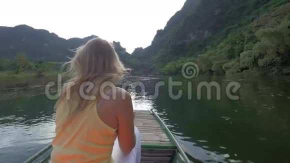 在河内的一个白庄越南女孩坐在河上用单反相机拍摄视频的预览图
