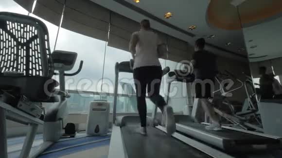 在中国香港年轻男女在跑步机上健身视频的预览图