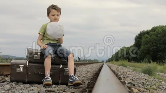 坐在铁路上的快乐小男孩视频的预览图