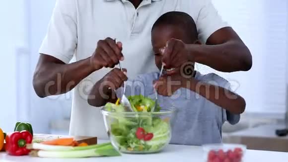 一位父亲教儿子如何混合沙拉视频的预览图