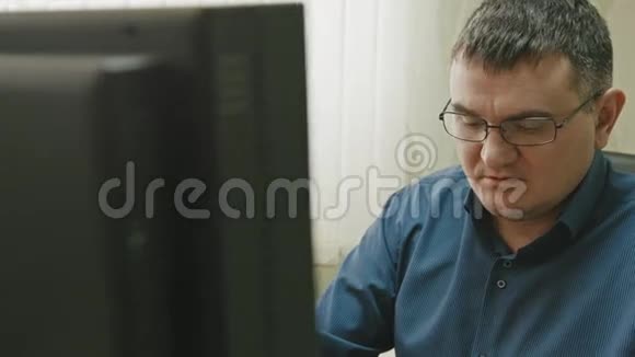 办公室工作人员戴眼镜的人在电脑上工作关门视频的预览图