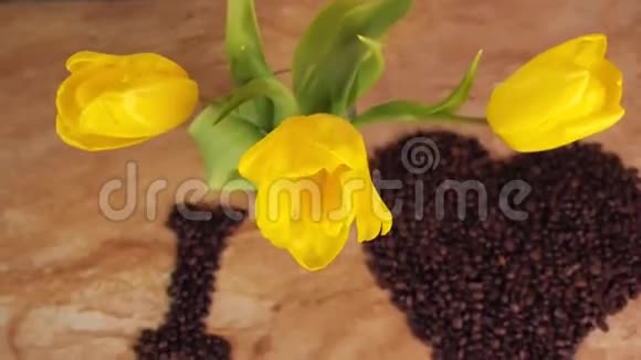 咖啡豆的铭文咖啡豆的心脏我喜欢咖啡的铭文在厨房的桌子上带着黄色的郁金香视频的预览图