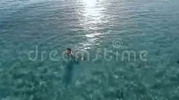 美丽的女孩在蓝色的海洋里游泳视频的预览图