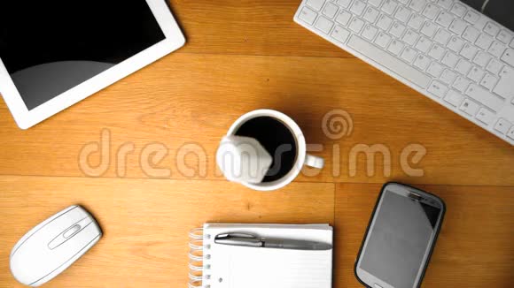 在平板电脑和智能手机旁的一杯咖啡里倒入糖块视频的预览图
