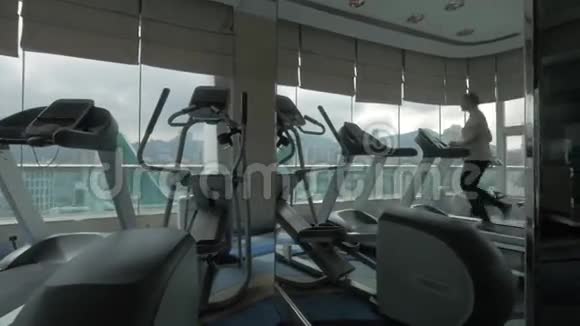 女子在全景窗前的机器上锻炼视频的预览图
