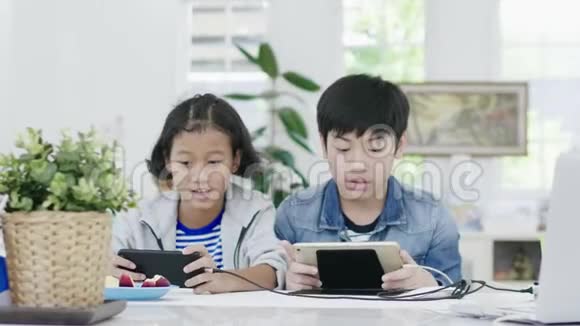 接近亚洲可爱的女孩和小男孩在智能手机上玩竞争性电子游戏视频的预览图