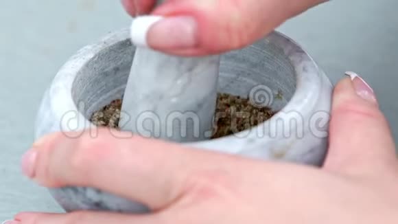 女用手在研钵里剁辣椒调味黑胡椒视频的预览图