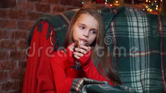 穿着红色毛衣的女孩若有所思地坐着喝茶视频的预览图