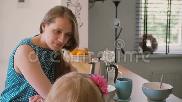 一位美丽的年轻母亲和她的女儿的特写她正在厨房的桌子上着色慢点斯泰迪达姆视频的预览图