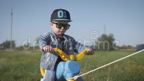 戴着滑稽眼镜骑自行车的幼儿帮助骑自行车学习骑自行车的概念视频的预览图