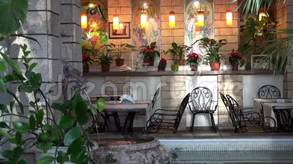 设计和室内有温暖的灯光和氛围喷泉桌子在城市的一个舒适的餐厅视频的预览图