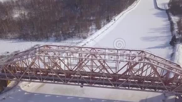 冬季景观冻江上列车运行的顶视悬索铁路桥梁空中观景火车桥视频的预览图