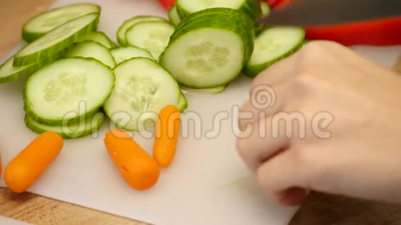正上方的妇女切胡萝卜的木板在柜台上放着一些新鲜蔬菜视频的预览图
