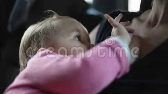 女人喂她坐在车里的孩子视频的预览图