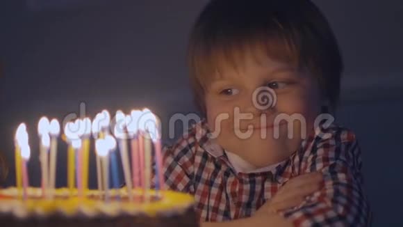 微笑的男孩在你慢动作地吹灭生日蛋糕上的蜡烛之前许了个愿视频的预览图