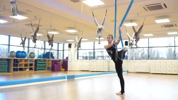 慢动作教练在地板上做体操运动从吊床到飞行瑜伽视频的预览图
