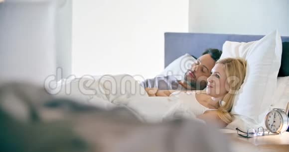 金发女人和男人微笑拥抱和休息恋爱中的情侣在卧室里醒来高加索人视频的预览图