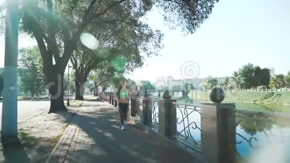 活跃的妇女慢跑在阳光明媚的城市公园慢动作视频的预览图