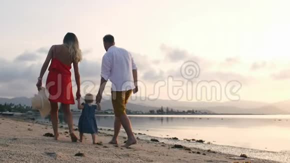 一家人带着孩子在海滩散步视频的预览图