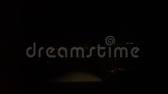 飞机窗口座位夜晚的洛杉矶和飞行中的飞机翼在城市灯光下的空中旅行视频的预览图