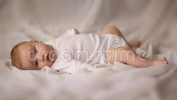 四个月大的婴儿躺在白色背景上的肖像视频的预览图