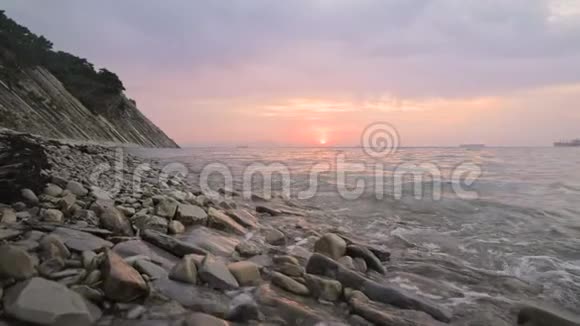 特写慢动作低宽角度小海浪在岩石海滩上翻滚沿着海滩向前移动海滨视频的预览图