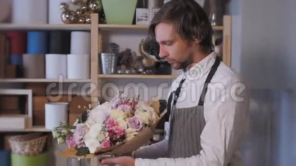 快乐微笑的花艺人在花店做时装束人商业销售和花卉的概念布格视频的预览图