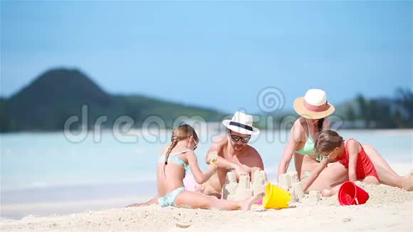 暑假期间一家人在白色海滩上制作沙堡视频的预览图