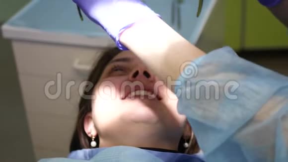 带着干细胞学家的女孩戴着特殊的防护眼镜检查牙齿4k3840x2160视频的预览图