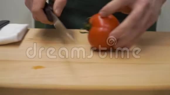 把番茄切成两半剪辑烹饪食物和家庭概念关闭男性手切胡椒在砧板上视频的预览图