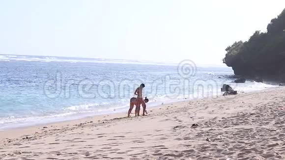 年轻的女人在海滩上发现贝壳海洋印度尼西亚巴厘视频的预览图
