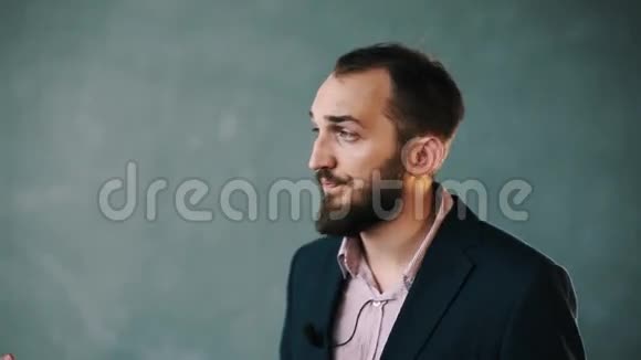 穿着夹克和条纹衬衫的大胡子男人笑着回答问题视频的预览图