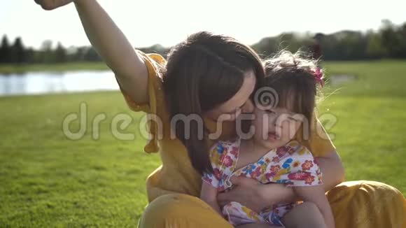 妈妈和美丽的女儿在草地上笑视频的预览图