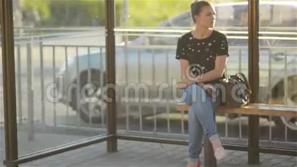 美丽的年轻女子在城市火车站等公共交通工具视频的预览图