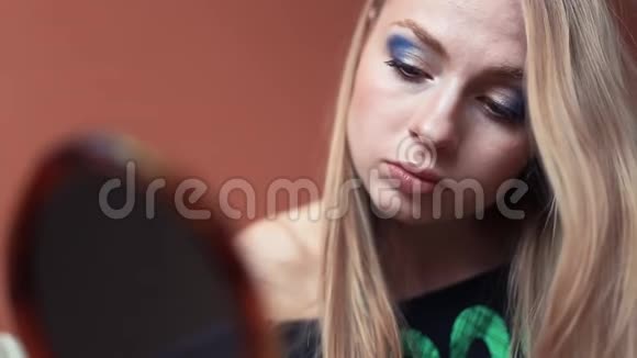 有魅力的女人做她的化妆戴上蓝色的眼影视频的预览图
