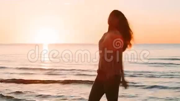 日落时分在海里摆姿势的女孩视频的预览图