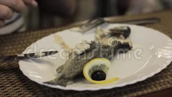 女人在咖啡馆里用双手放在白色盘子上吃鱼视频的预览图