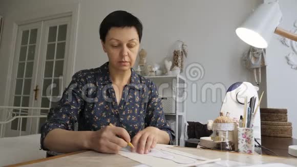 女人正在工作室桌子上做缝纫图案视频的预览图