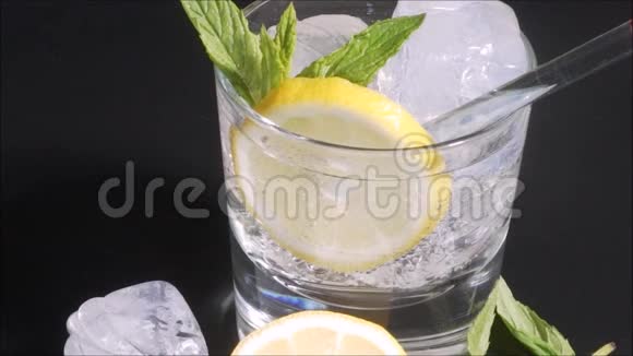 伏特加柠檬加冰和薄荷叶在黑色背景视频的预览图