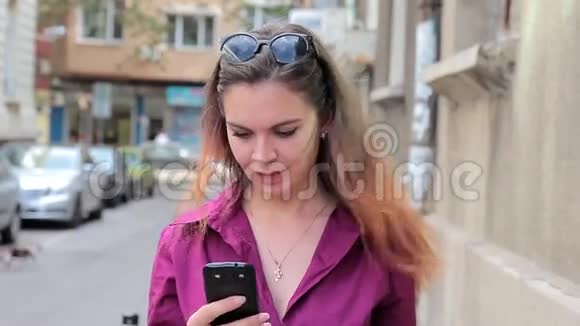 在街上看手机的年轻女子视频的预览图