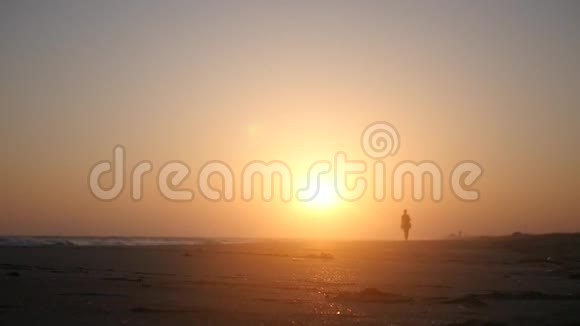 在美丽的夕阳下独自走在海边的沙滩上高清1920x1080慢动作视频的预览图